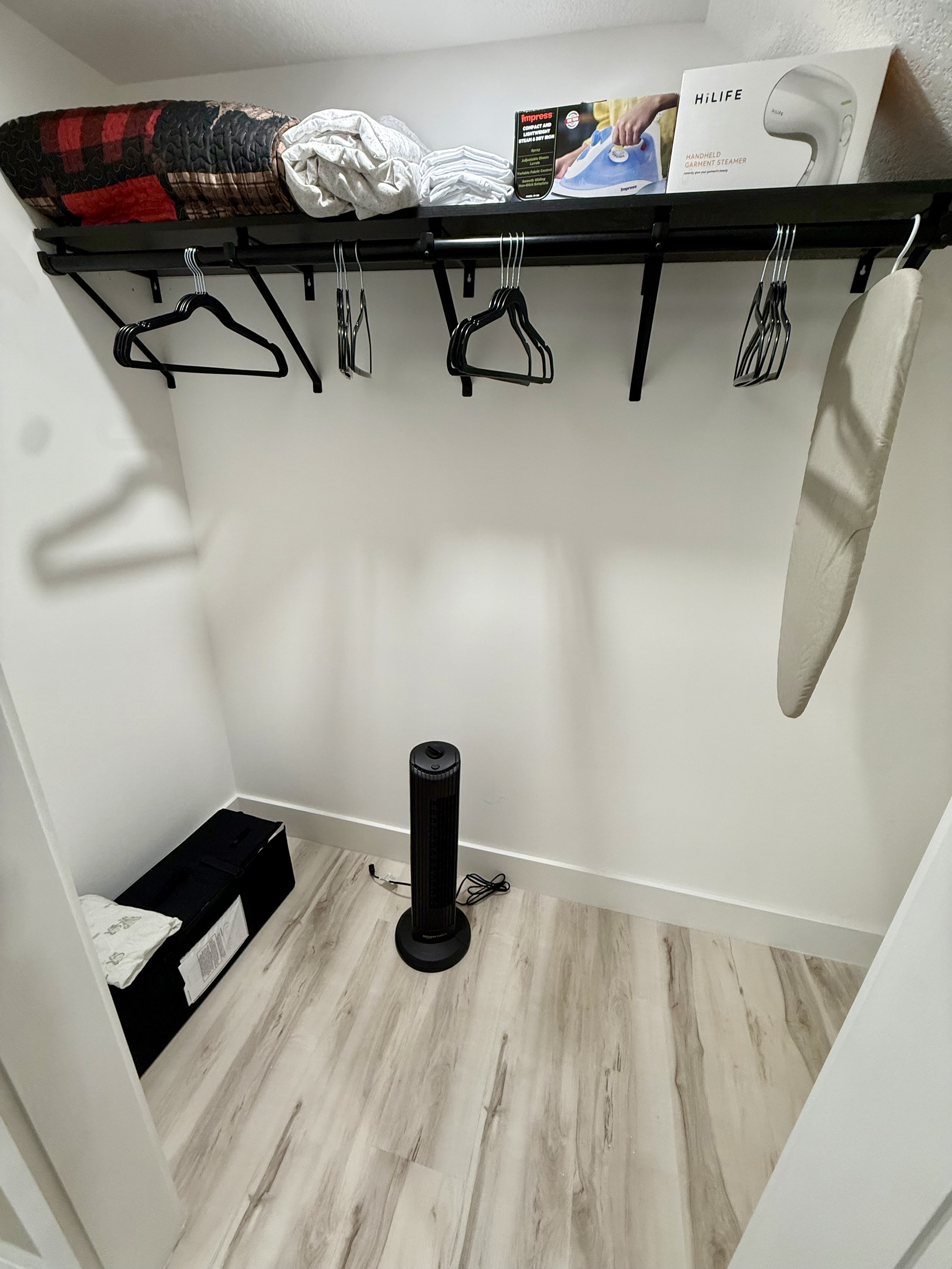 Master closet with fan, pack and play portable crib, iron, ironing board, and steamer