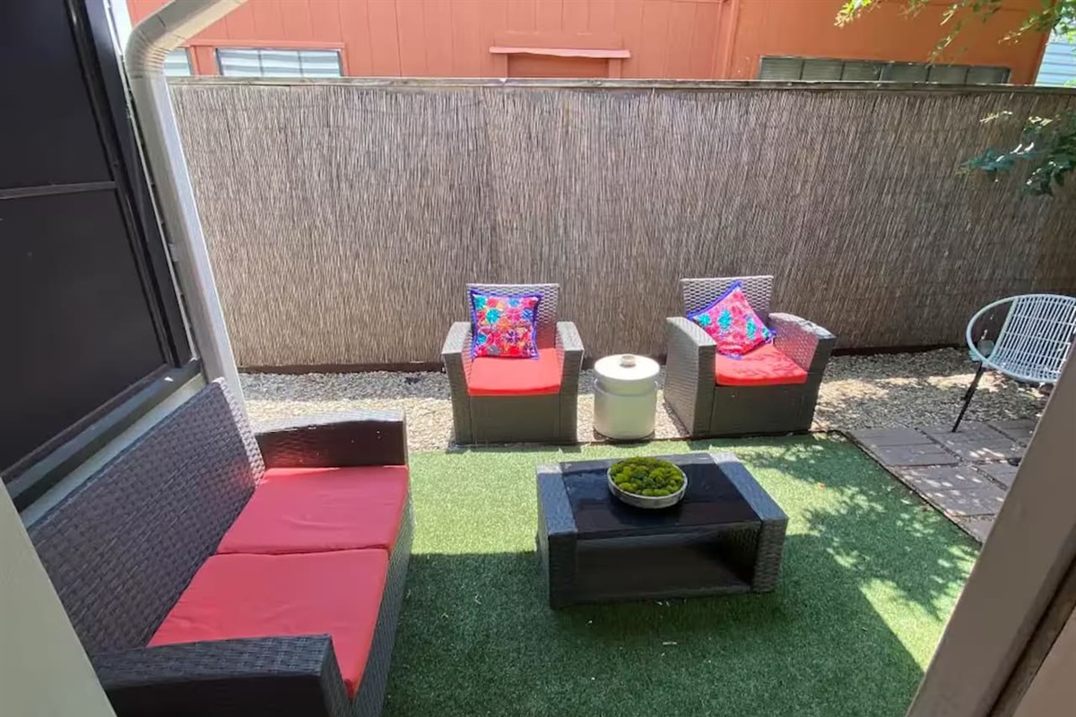 Backyard with patio seating and kid-friendly play space.