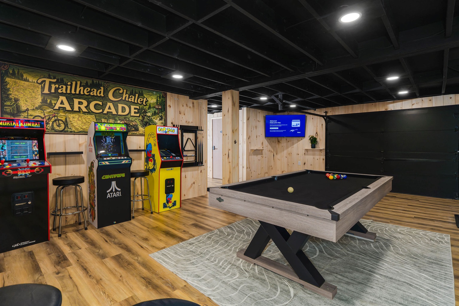 🕹️ A fully loaded game room: three arcade cabinets, pool, foosball, and bar seating — the rainy-day and after-dark headquarters.