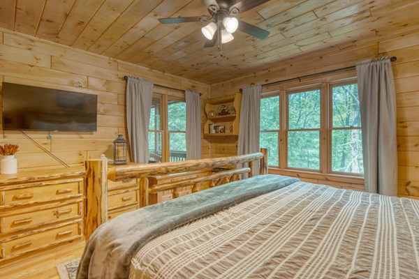 Primary bedroom with king bed, smart tv, and view of the creek
