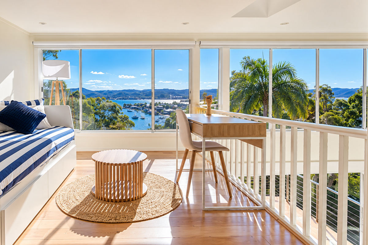 Natural light fills this peaceful upstairs retreat, complete with a cosy daybed, practical workspace and sweeping water views.