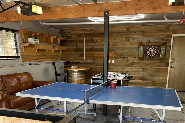 table tennis, foosball, darts, and chessboard table located in garage