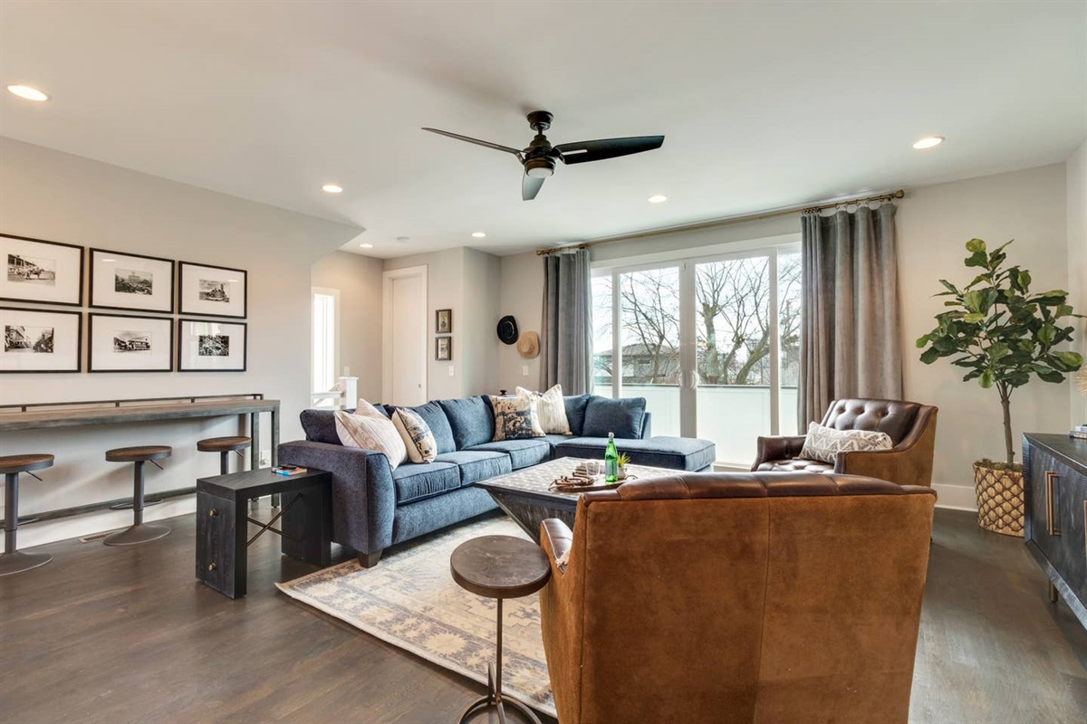 - Large sectional, leather chairs, & rich textures create a cozy & stylish gathering space - Wall to wall windows brighten the room & highlight the clean modern aesthetic - Bar seating & curated decor perfect for entertaining or unwinding with a movie