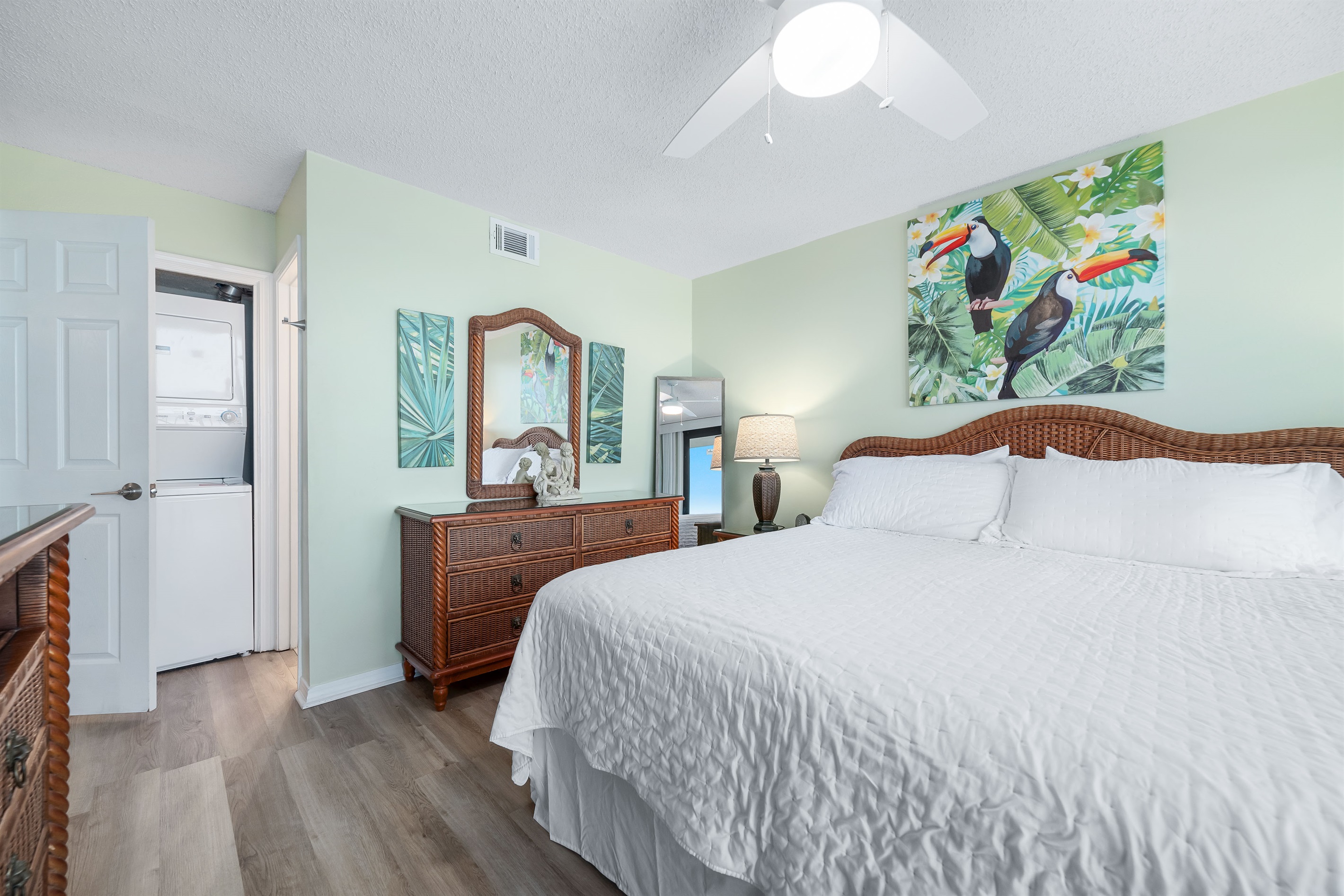 Enjoy breathtaking ocean views from this spacious bedroom featuring a comfortable bed, ample storage, and direct access to a private balcony.