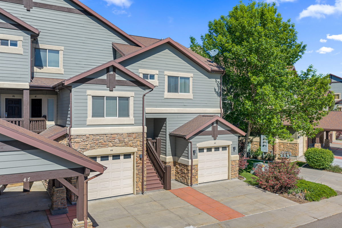 Exterior view of our Lakeside Village townhome featuring mountain-style architecture, private garage access, and a beautiful setting near Pineview Reservoir and Snowbasin Resort.