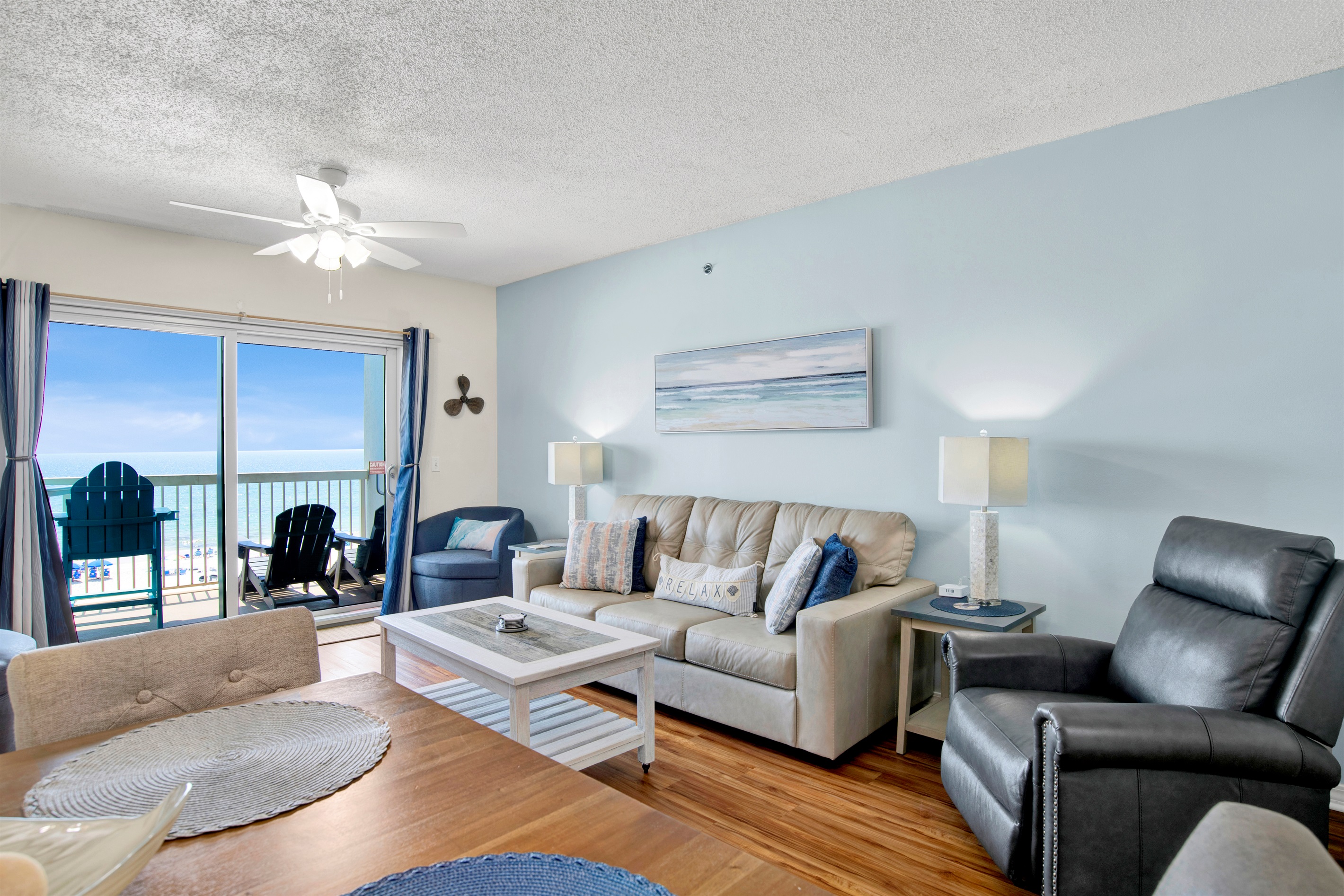 Living room with sleeper sofa, recliner, arm chair, ceiling fan, wall mounted Smart TV and a great Gulf and beach view 