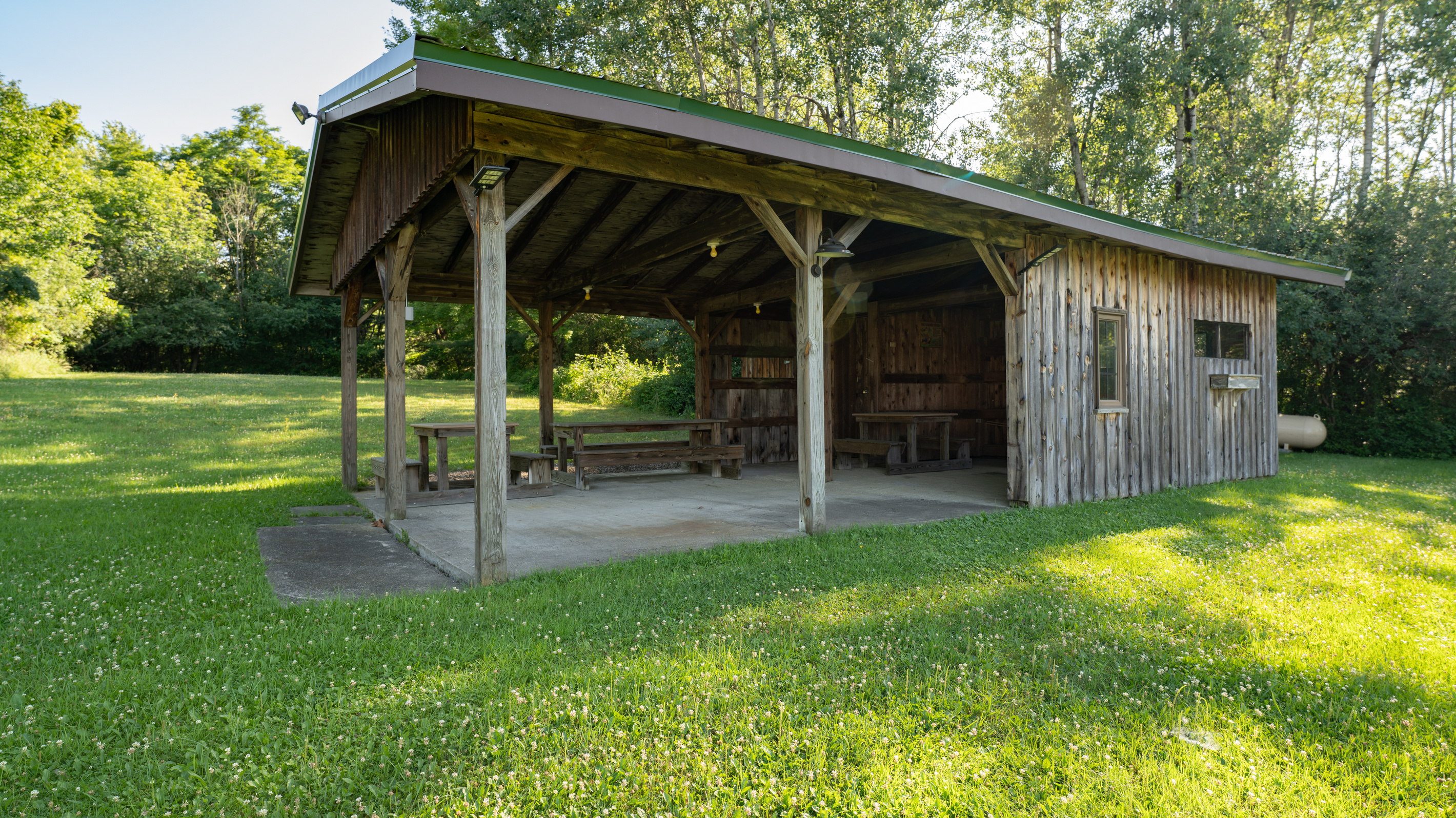 Covered open-sided structure beside the lawn