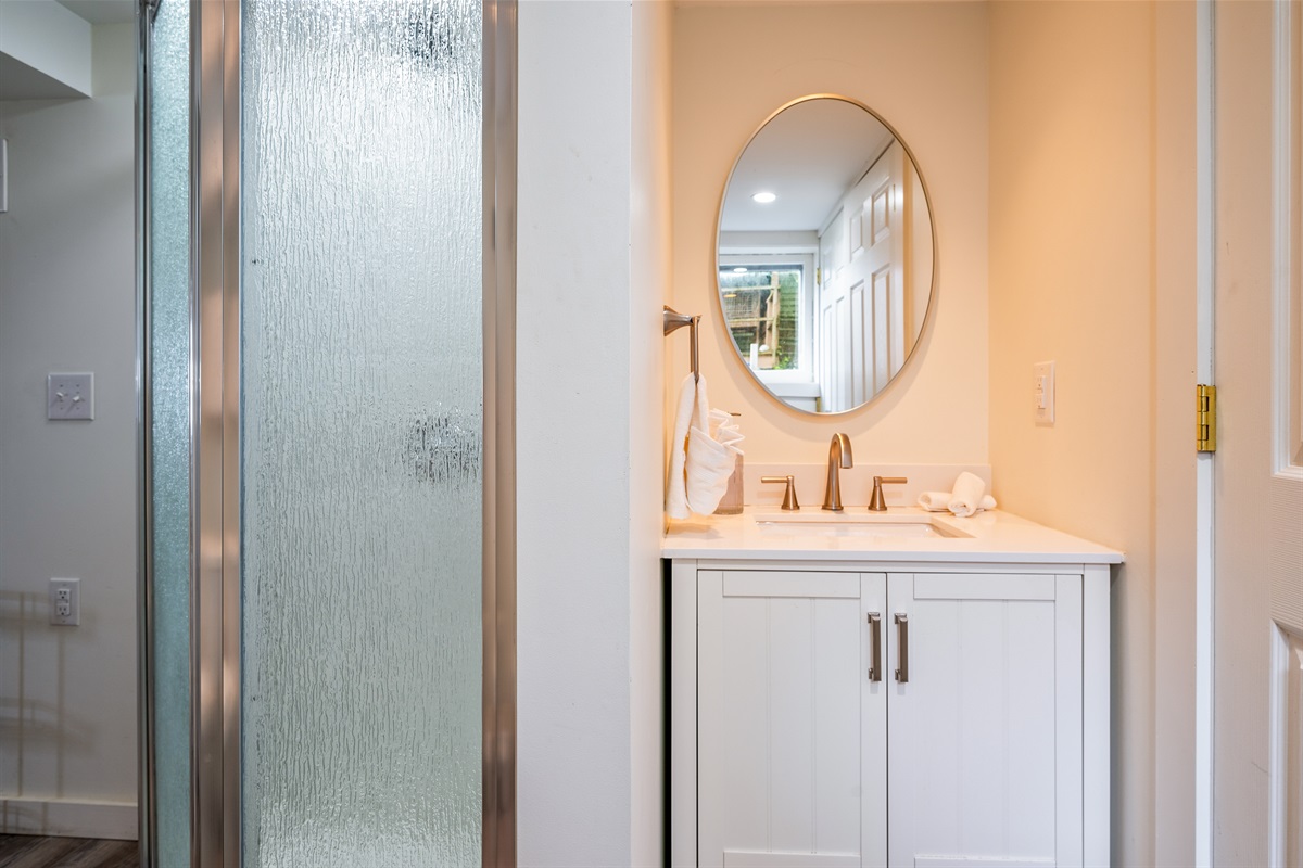 Stylish vanity with gold fixtures and a round mirror brings modern charm to this light-filled bathroom ✨