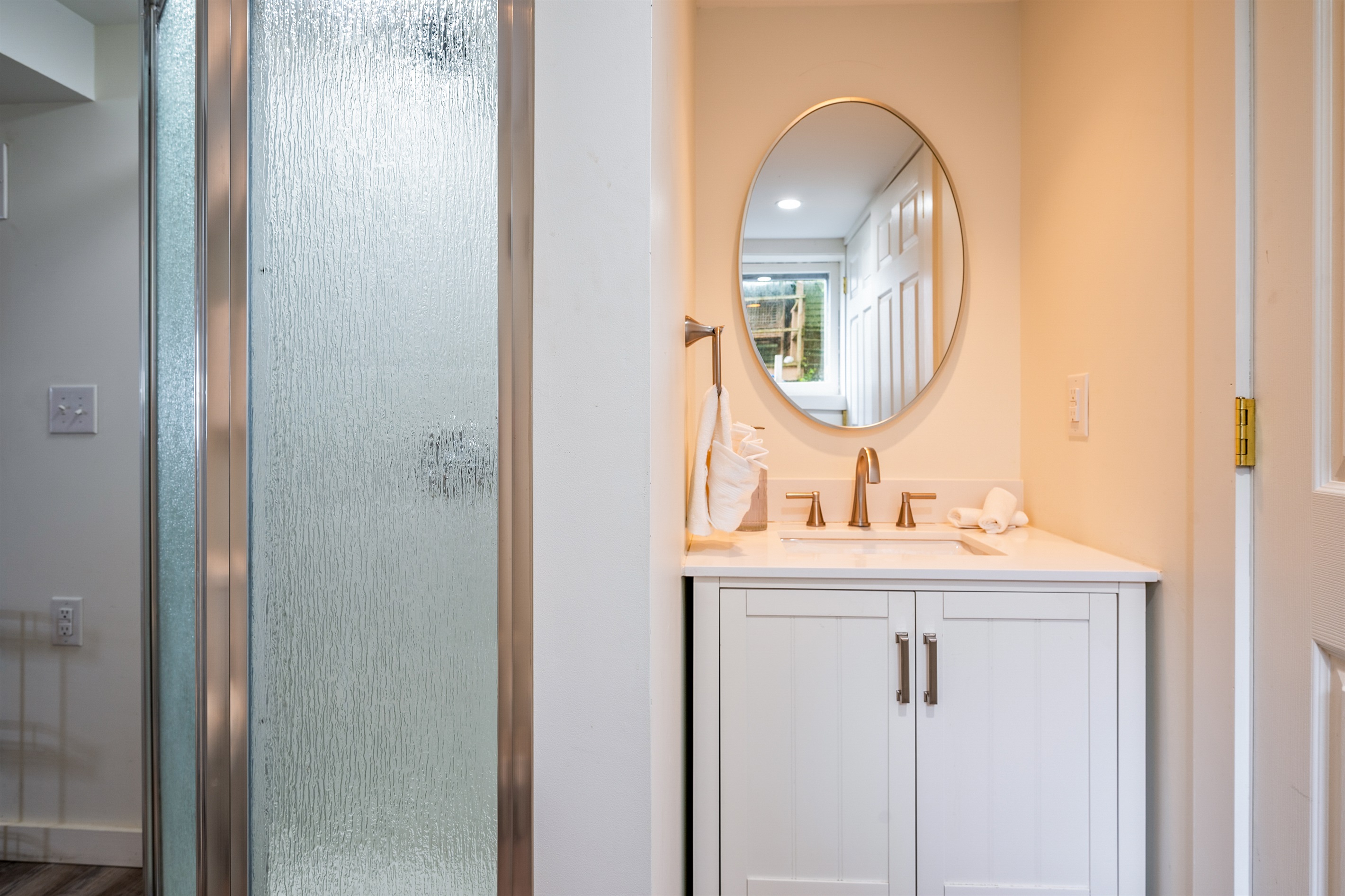 Stylish vanity with gold fixtures and a round mirror brings modern charm to this light-filled bathroom ✨