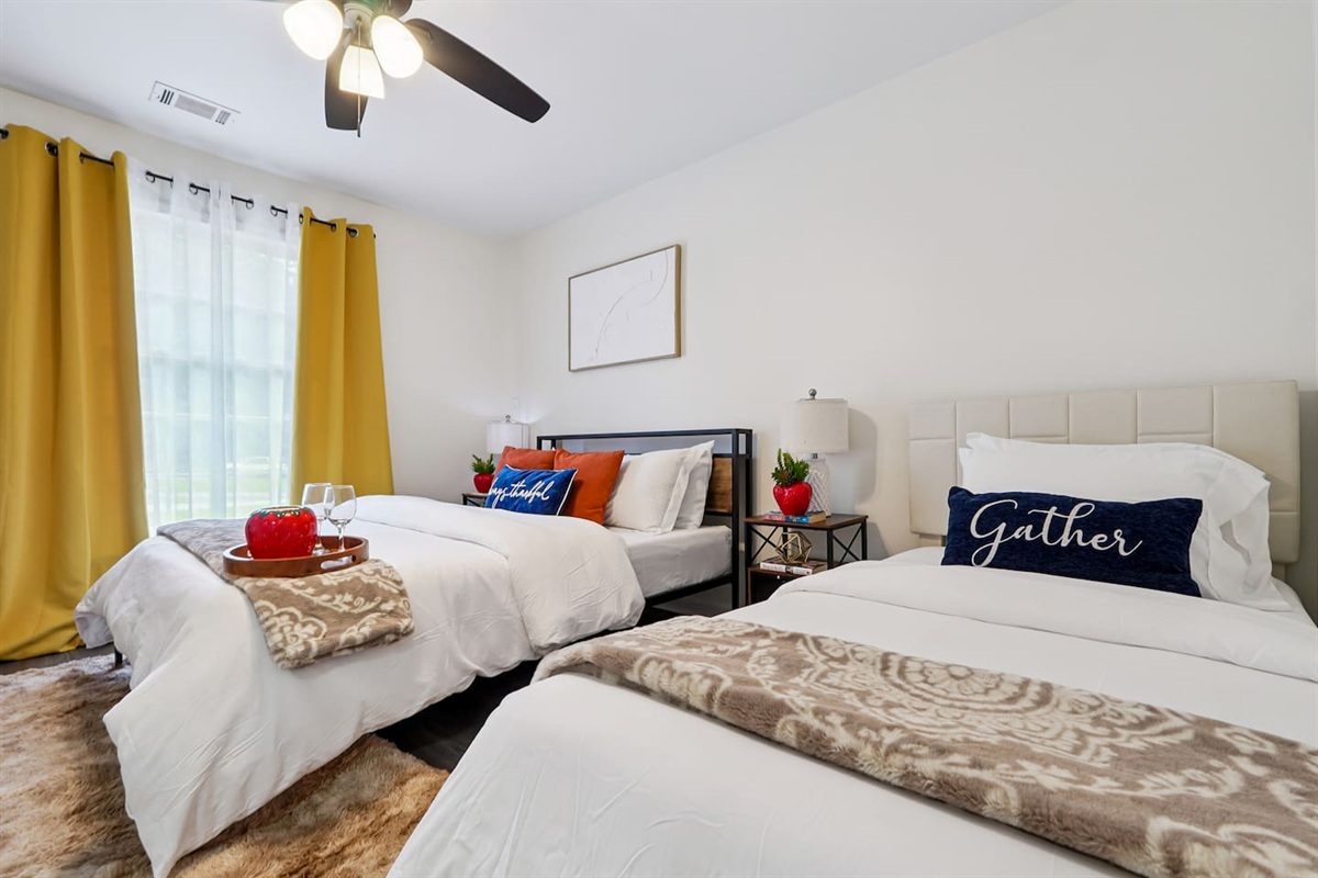 Another cozy bedroom featuring both a full bed and a twin bed, along with an Amazon Fire-powered Smart TV for your entertainment. This room includes 4 full-body towels, 4 washcloths, and 2 hand towels for your stay.