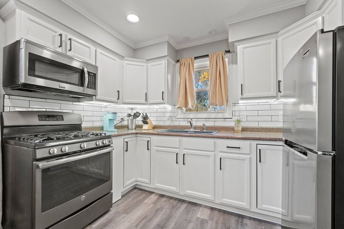 Fully equipped kitchen with a fridge, microwave, gas stove with oven, knife set, and all the essential cookware for your convenience.