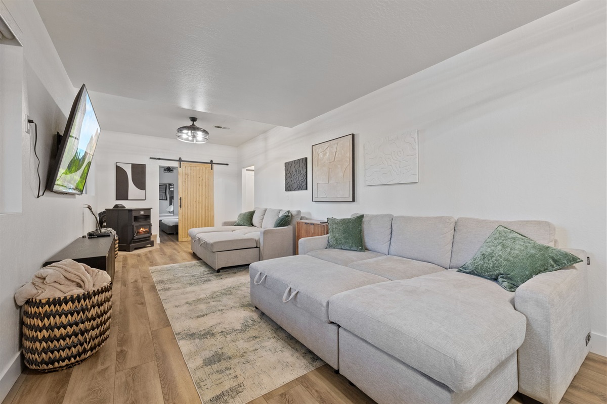 Living room downstairs with 2 pull out sofa beds, big screen tv, pellet stove and kareoke stereo set.