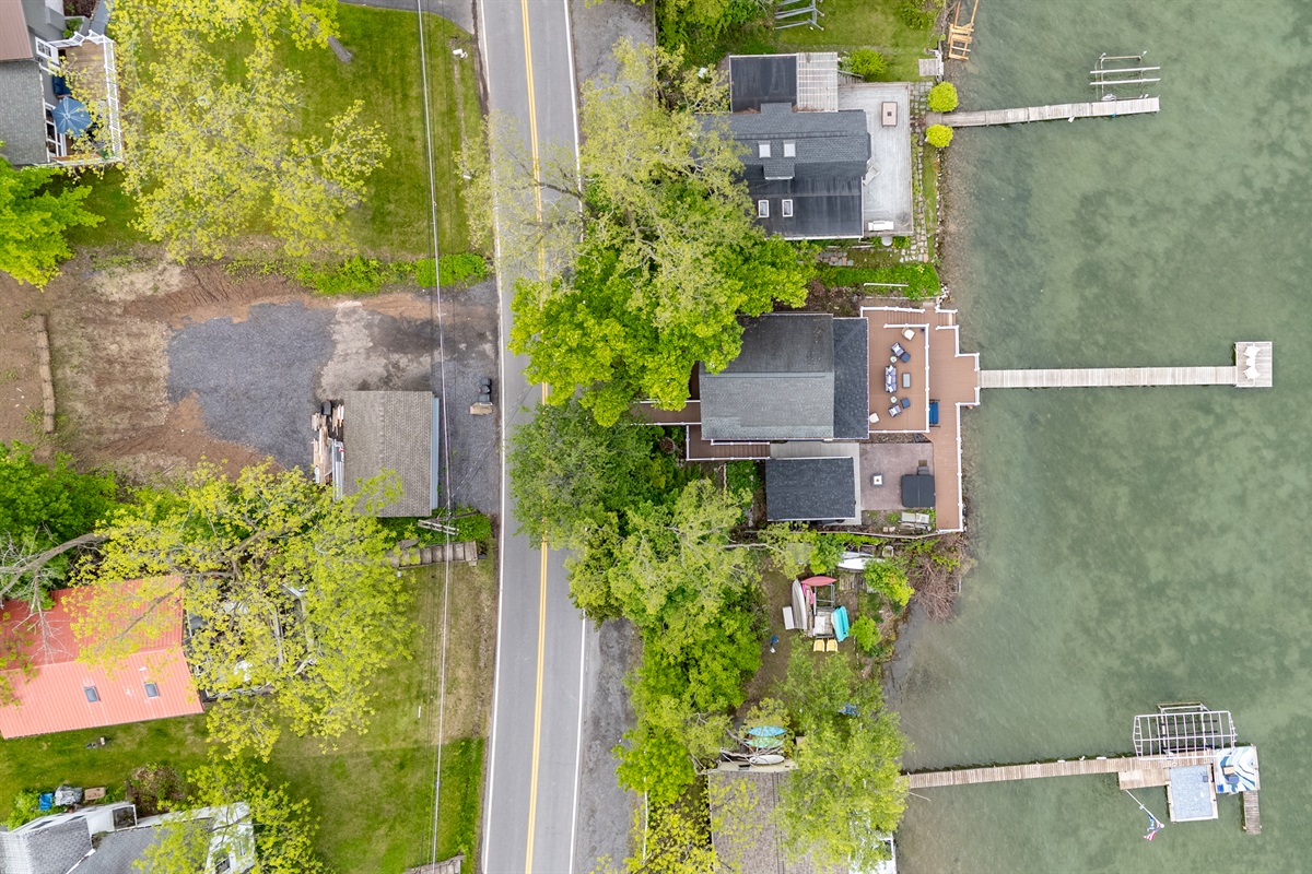 Aerial shot showcasing expansive lakefront entertaining space, hot tub, and private dock for the ultimate getaway 🎯🌊🍹