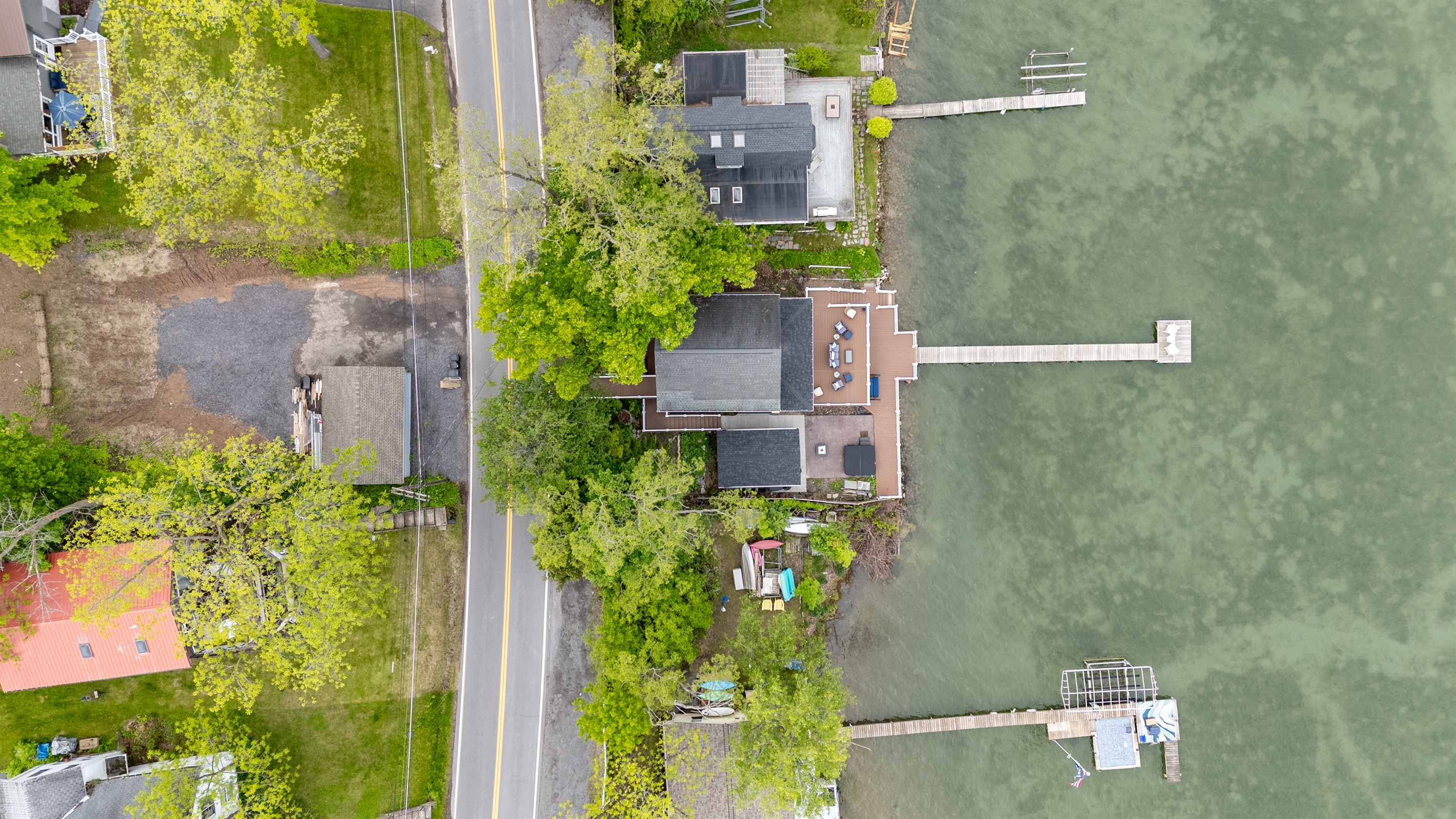 Aerial shot showcasing expansive lakefront entertaining space, hot tub, and private dock for the ultimate getaway 🎯🌊🍹