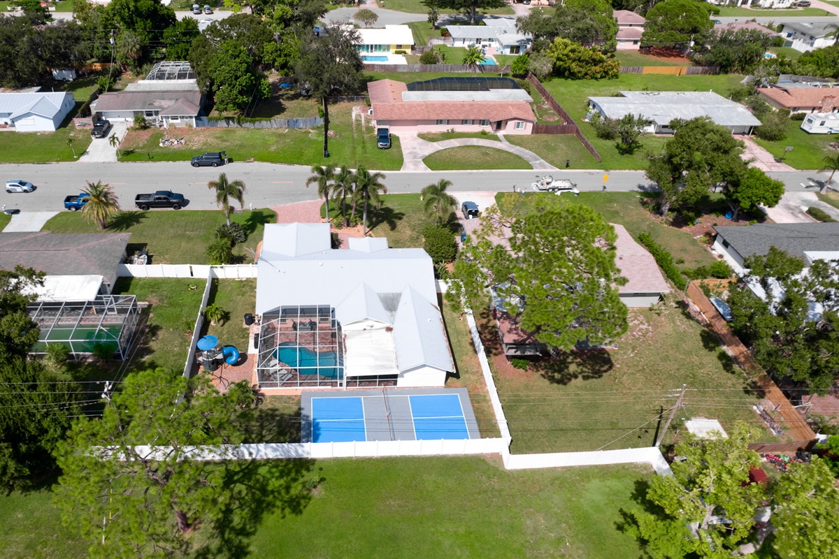 Take in the full picture of your private getaway — a stunning aerial view showcasing the sparkling pool, fun-filled playset, and pickleball court, all surrounding your beautiful vacation home. The ultimate family retreat awaits!