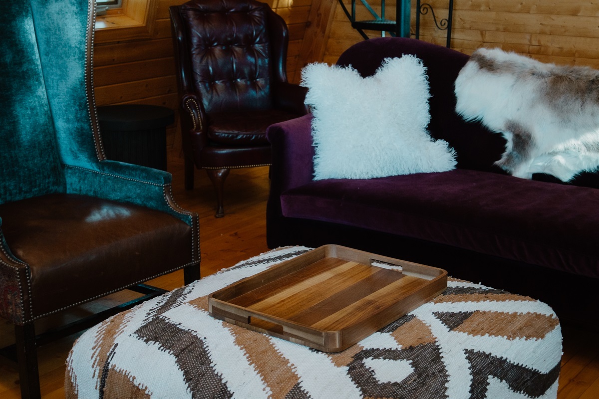 Cozy mountain living room with curated vintage seating. This A-frame cabin features plush lounge chairs, warm wood walls, and inviting textures—perfect for relaxing after hiking, skiing, or exploring Arizona’s White Mountains.