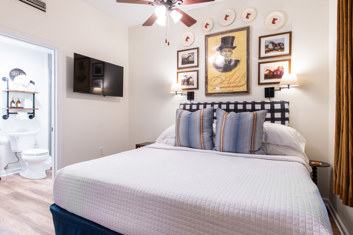 The bedroom, with a television and adjoining bathroom visible.