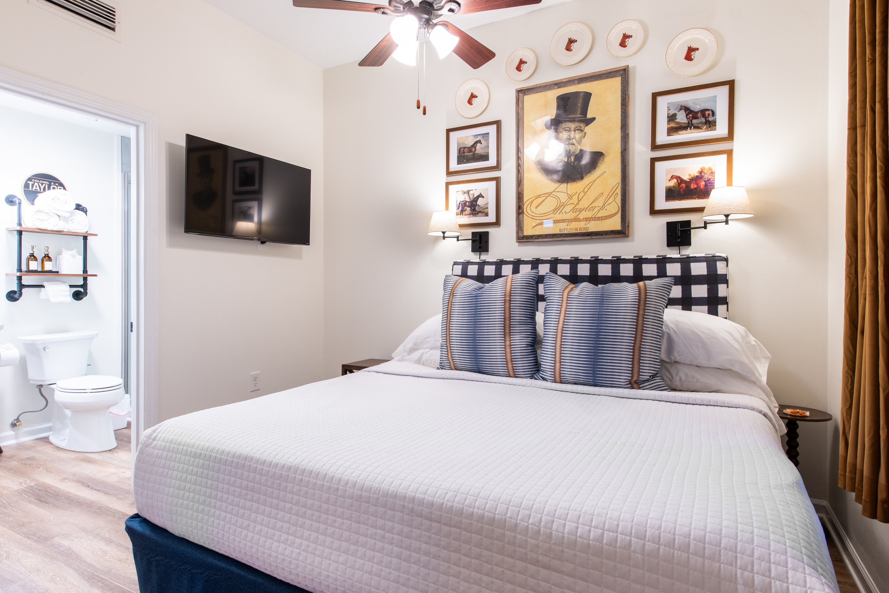 The bedroom, with a television and adjoining bathroom visible.