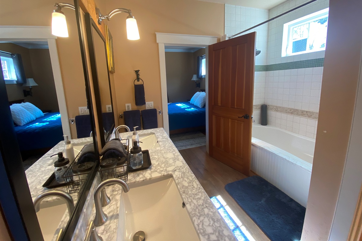 The primary bathroom features dual sinks, shower tub combination, a private toilet and a large walk-in closet. 