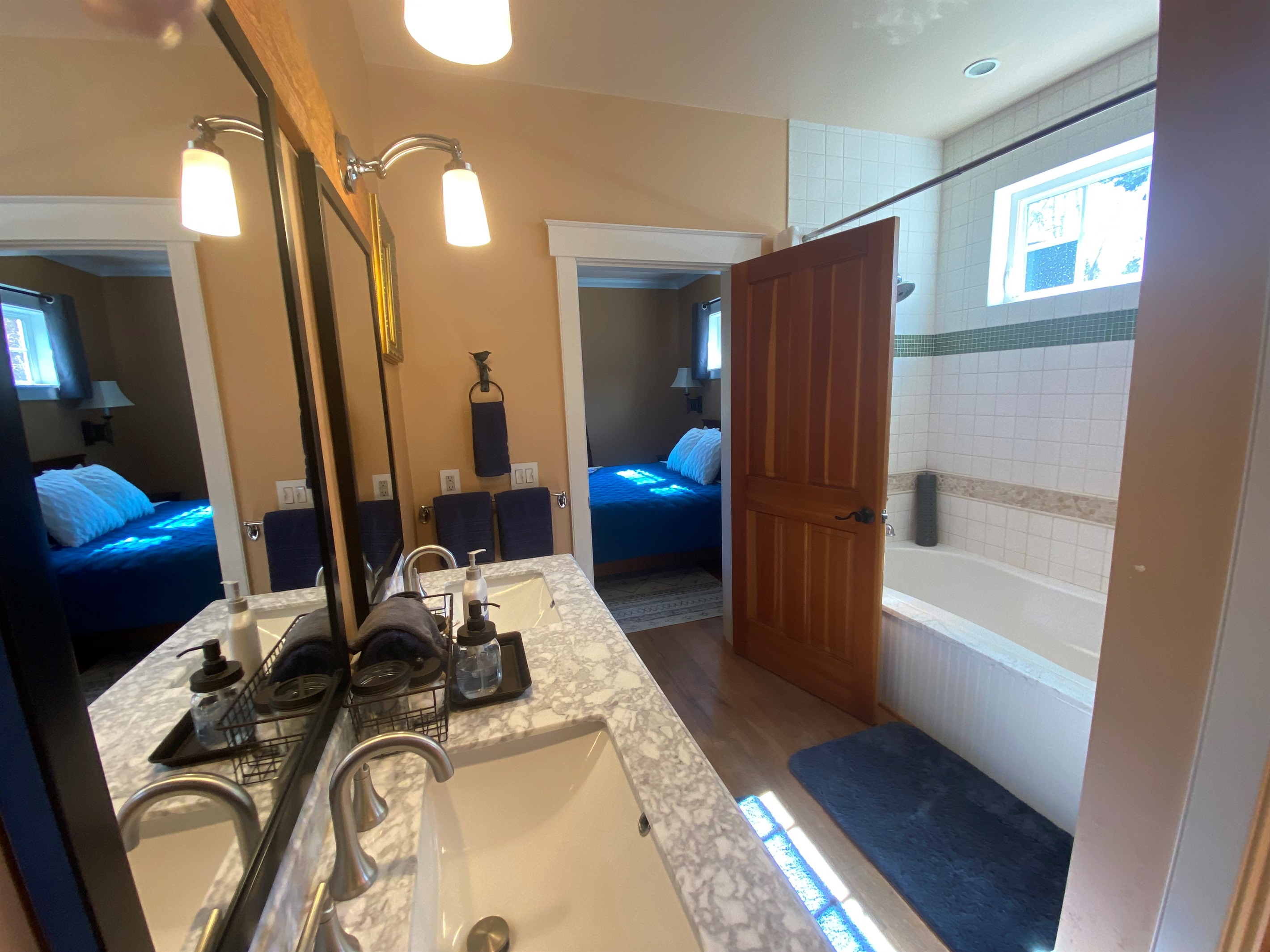 The primary bathroom features dual sinks, shower tub combination, a private toilet and a large walk-in closet. 