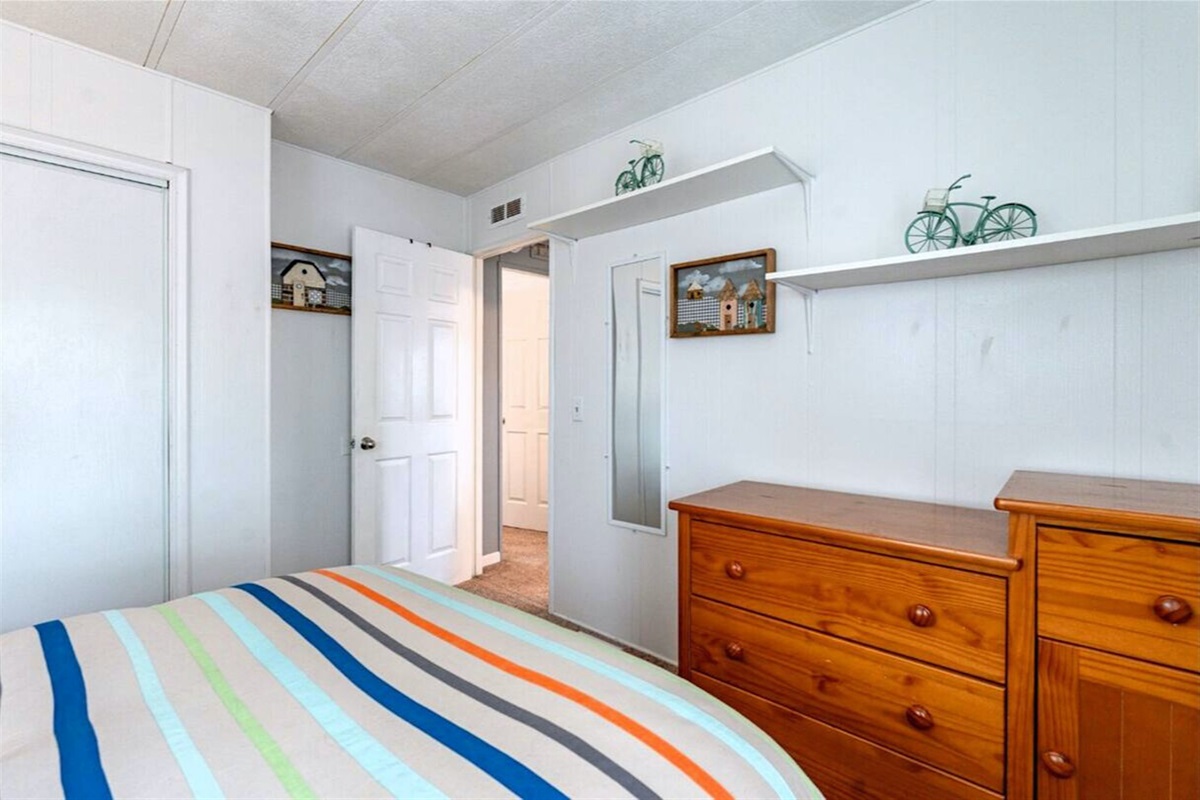 Cozy third bedroom with ample storage, including a spacious closet and dresser.