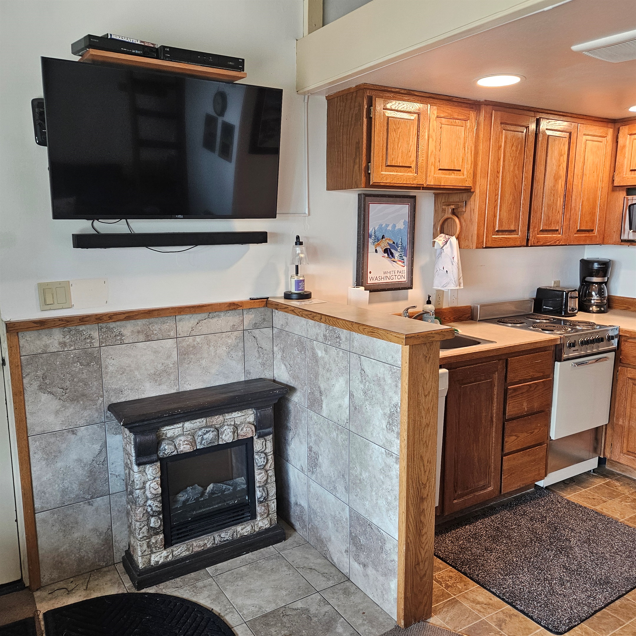 Electric fireplace next to kitchen.
