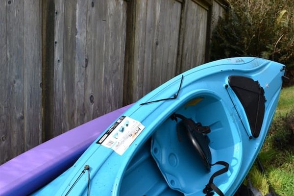 2 kayaks and a standup paddle board