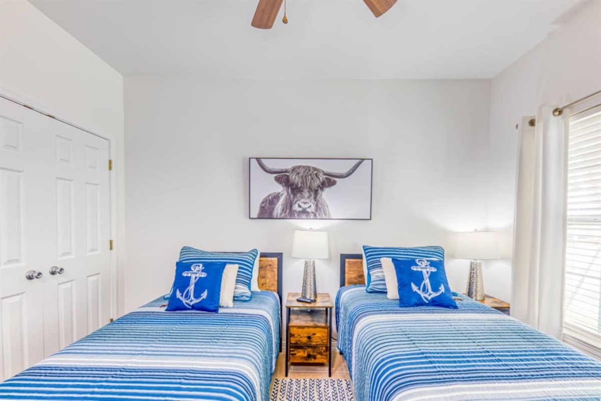 Guest Bedroom: Bright twin beds, nautical decor, and a charming bull artwork for playful vibes!