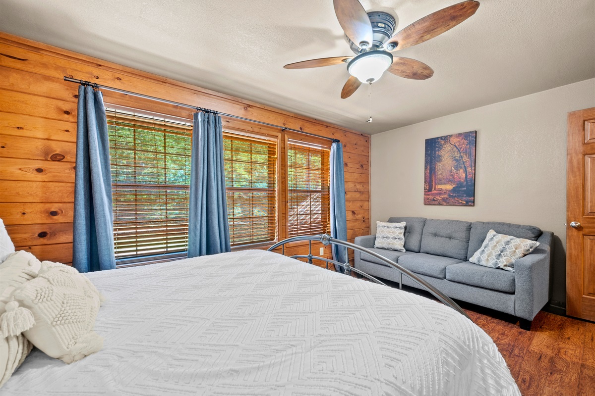 Wake up to tree-lined views and enjoy reading or relaxing on the loveseat.