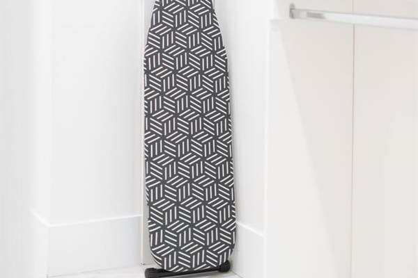Closet space featuring an ironing board and neatly folded fresh linens.