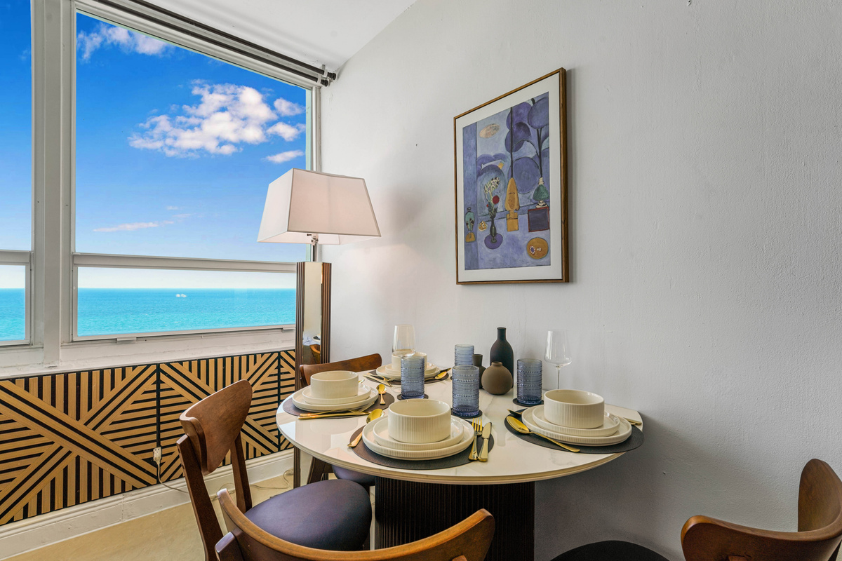 The round marble dining table seats four beside the window, so every breakfast comes with an ocean view.