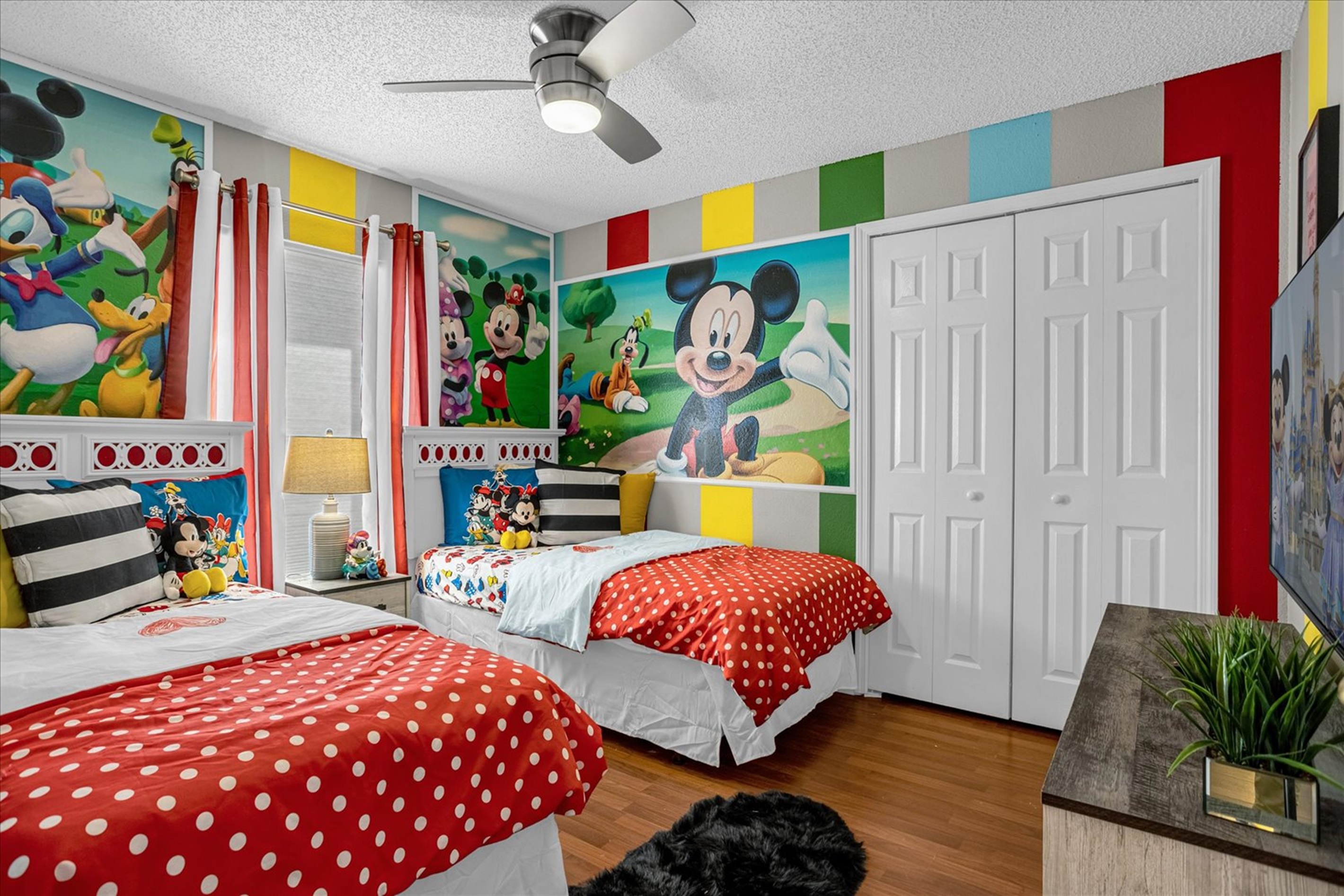 Children's bedroom featuring 2 twin beds with Mickey theme.