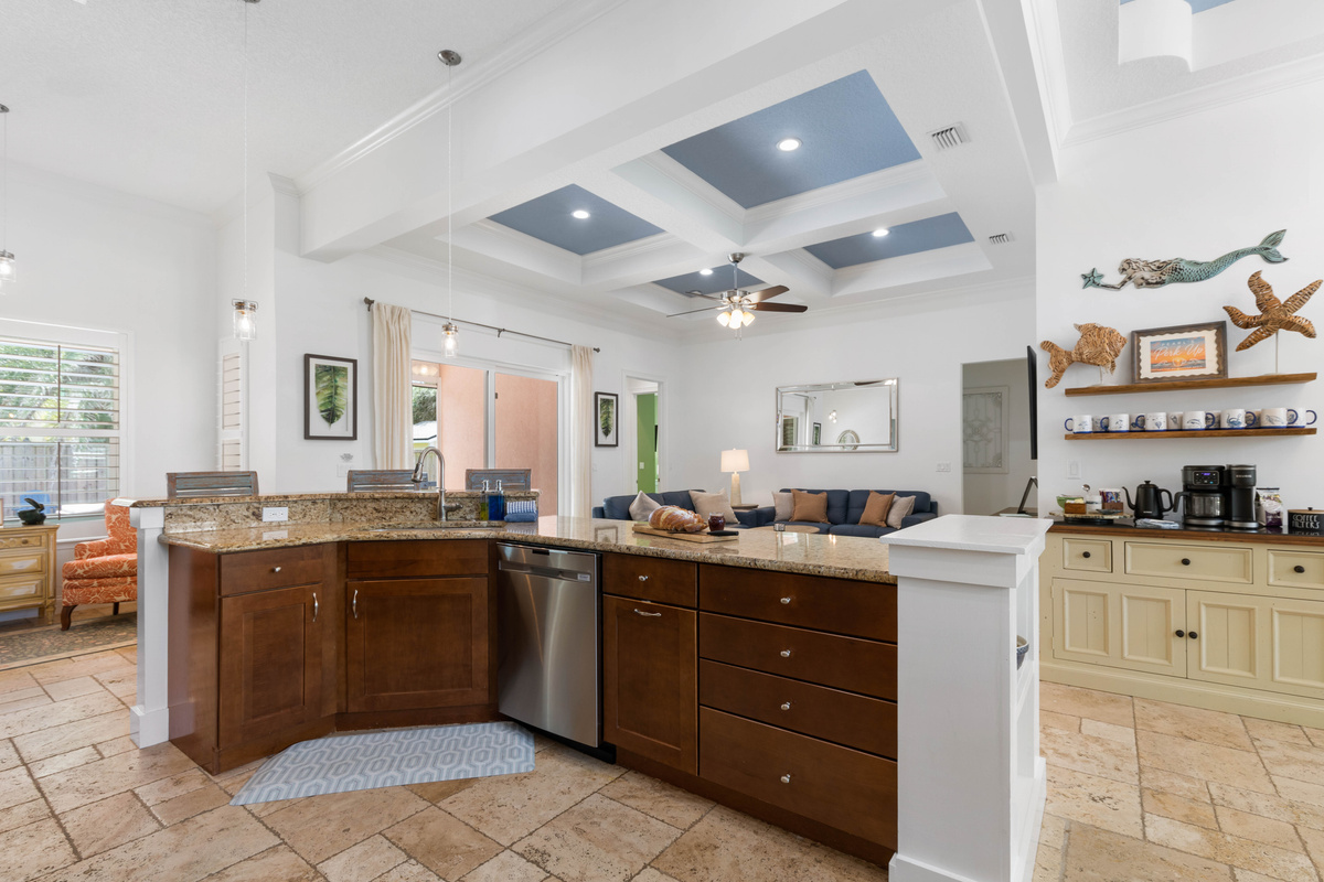 Kitchen peninsula with a dishwasher faces the living room and coffee bar, so cleanup never cuts you off.