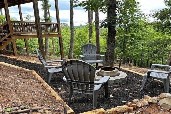 Private fire pit area beneath the trees, surrounded by Adirondack chairs - perfect for evening fires and mountain conversations.