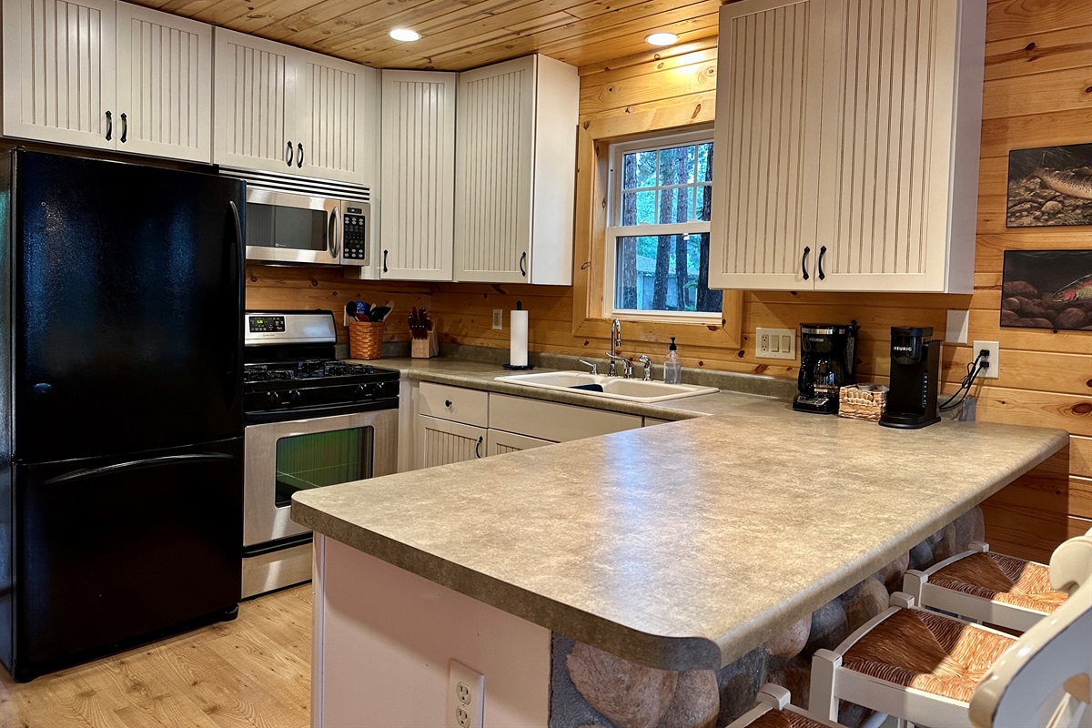 A warm and welcoming cabin kitchen with everything you need for weekend breakfasts, family dinners, morning coffee, and gathering together.