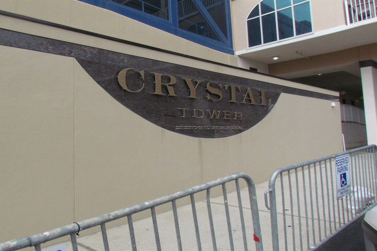 The sleek, modern design of the Crystal Tower entryway. Thoughtful details, from the material contrast to the reserved parking accessibility, define this premier property.