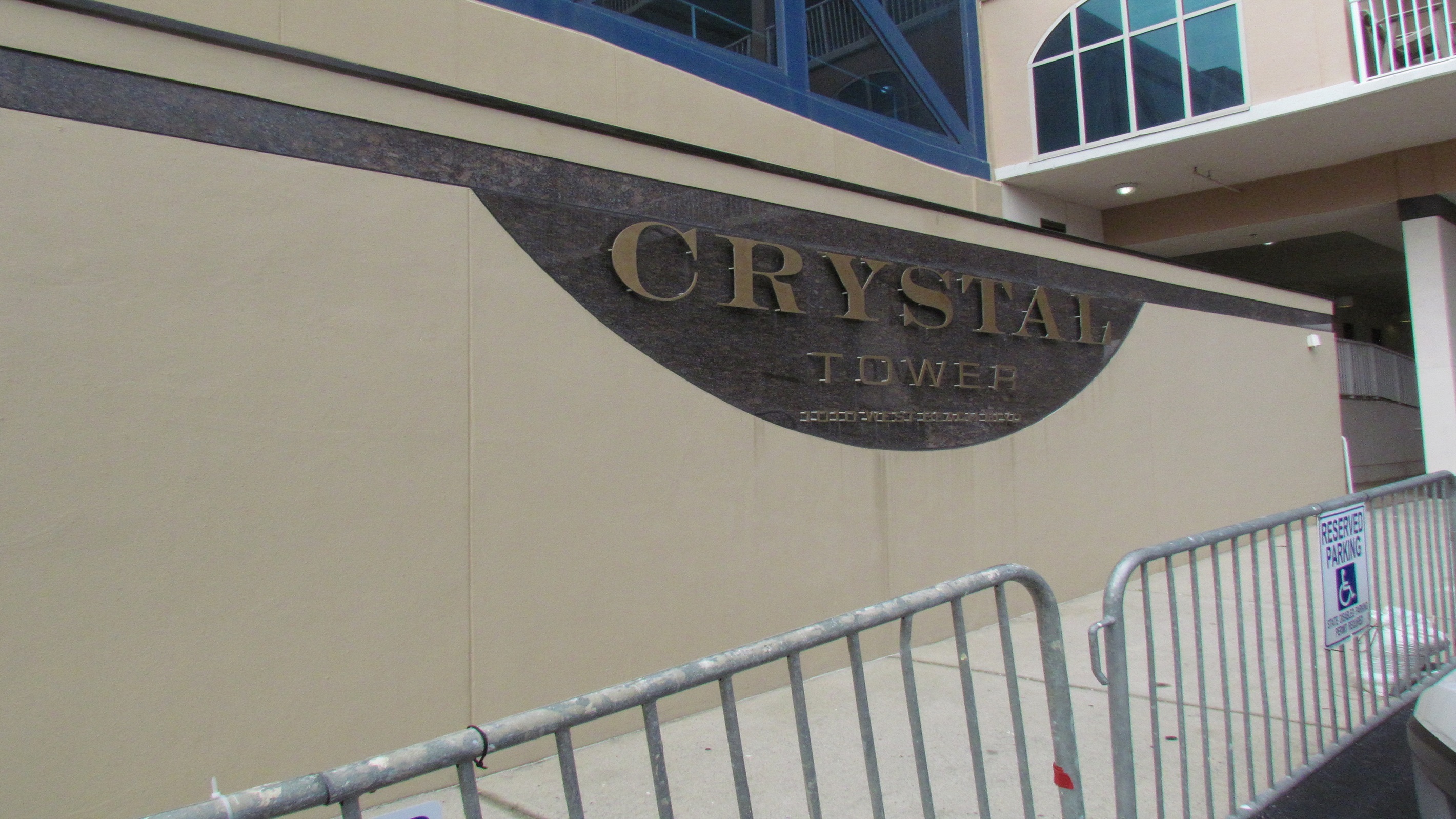 The sleek, modern design of the Crystal Tower entryway. Thoughtful details, from the material contrast to the reserved parking accessibility, define this premier property.