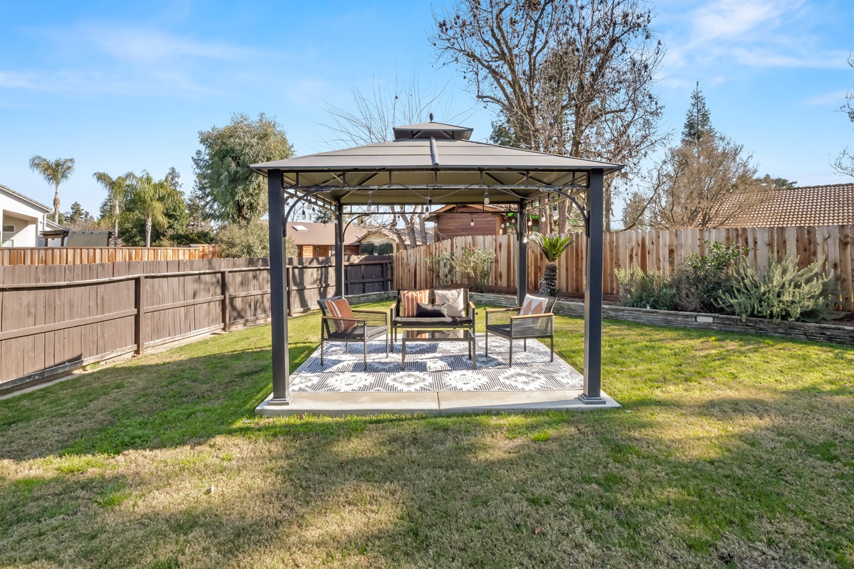 Gazebo-covered seating offers a cool, comfortable spot for parents to relax while kids play on the lawn.