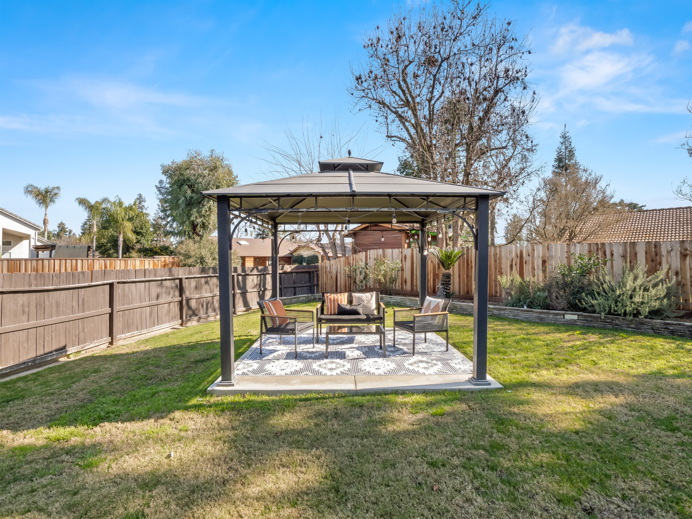 Gazebo-covered seating offers a cool, comfortable spot for parents to relax while kids play on the lawn.