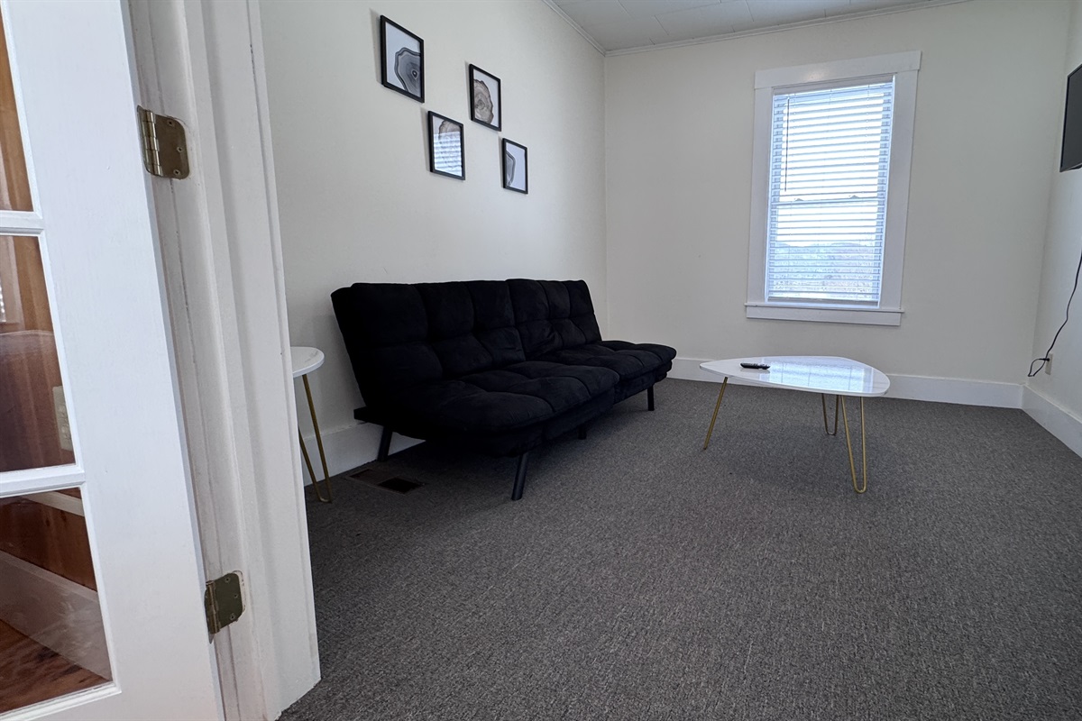 The study lounge off of the Primary Bedroom with a futon couch and TV
