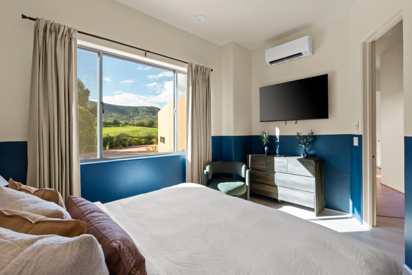 Wake up to direct golf course views and scenic mountain vistas, featuring a large smart TV and custom mini-split climate control.