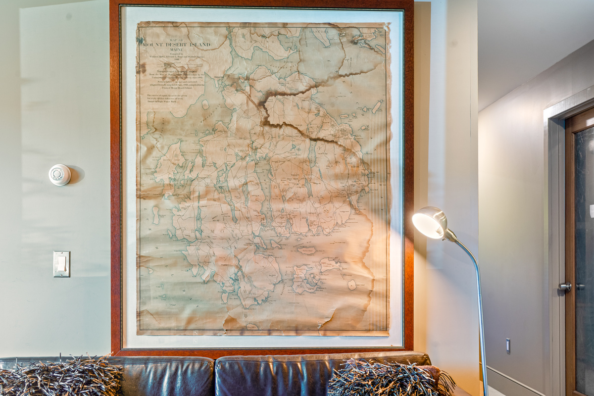 Lower level lounge featuring oversized vintage map artwork of Mount Desert Island. This dedicated social space is the perfect spot for groups to gather and plan their next Acadia National Park hiking route or day of island exploration.