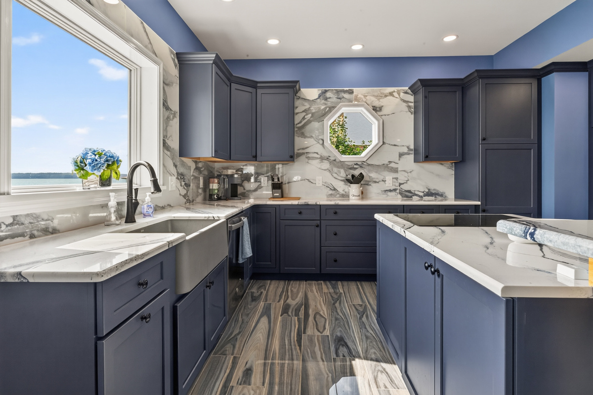 Blue cabinetry with stone countertops and backsplash