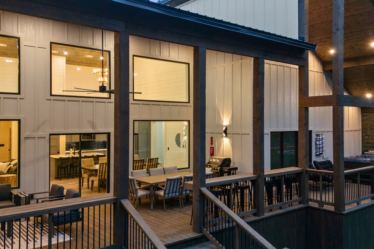 As evening arrives, the warm glow from inside the cabin shines through the large windows, creating a cozy and welcoming atmosphere.