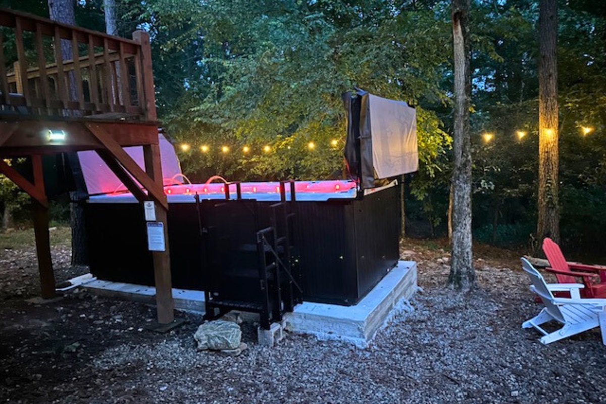 Elevated spa deck with a private swim spa and warm lighting, ideal for evening relaxation.