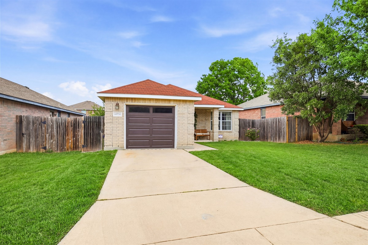 Brick exterior, attached garage, covered front entry, and lush green lawn. A quiet residential street with easy access to Loop 1604 and Hwy 151.