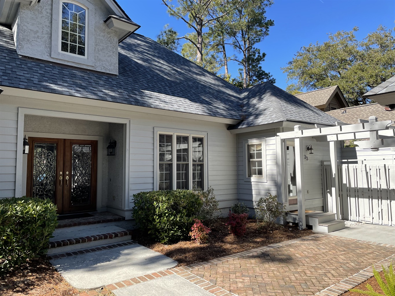 Brick walkway leads to side entrance of house and garage