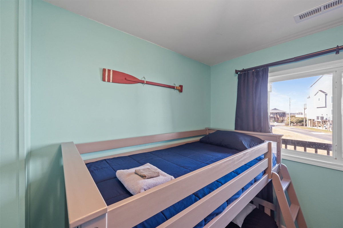 Comfortable twin bunk beds with soft bedding and a bright window that keeps the room light and cheerful