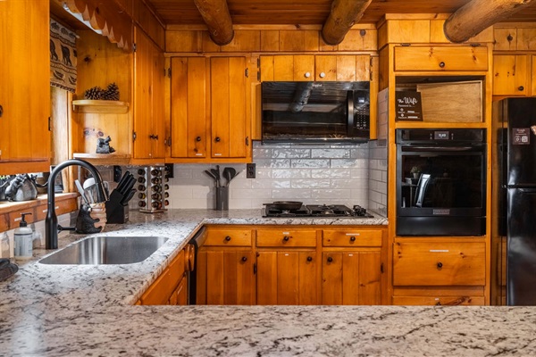 Gather for meals in our spacious kitchen and dining area—plenty of room for the whole crew with seating for 8 and a view of the woods through every window.