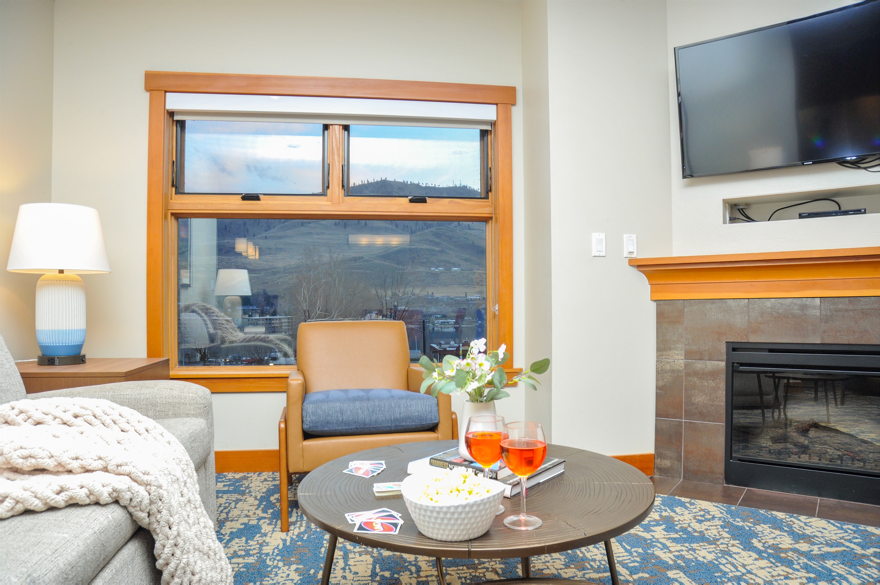 Open living room with TV, fireplace, lake view and with pull out couch